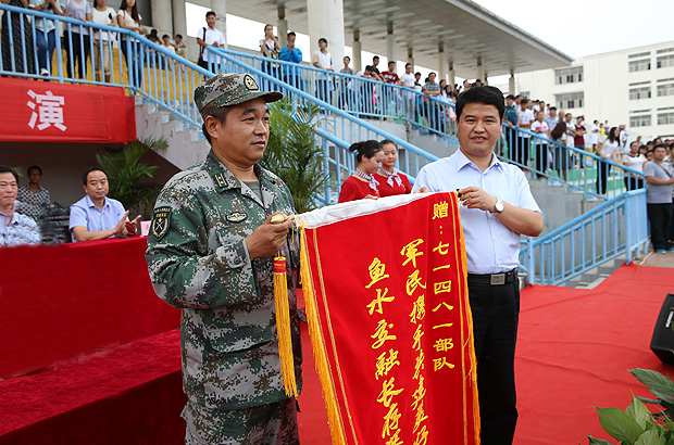 校黨委副書記劉榮增代表學(xué)校向軍訓(xùn)承訓(xùn)部隊(duì)贈(zèng)送錦旗